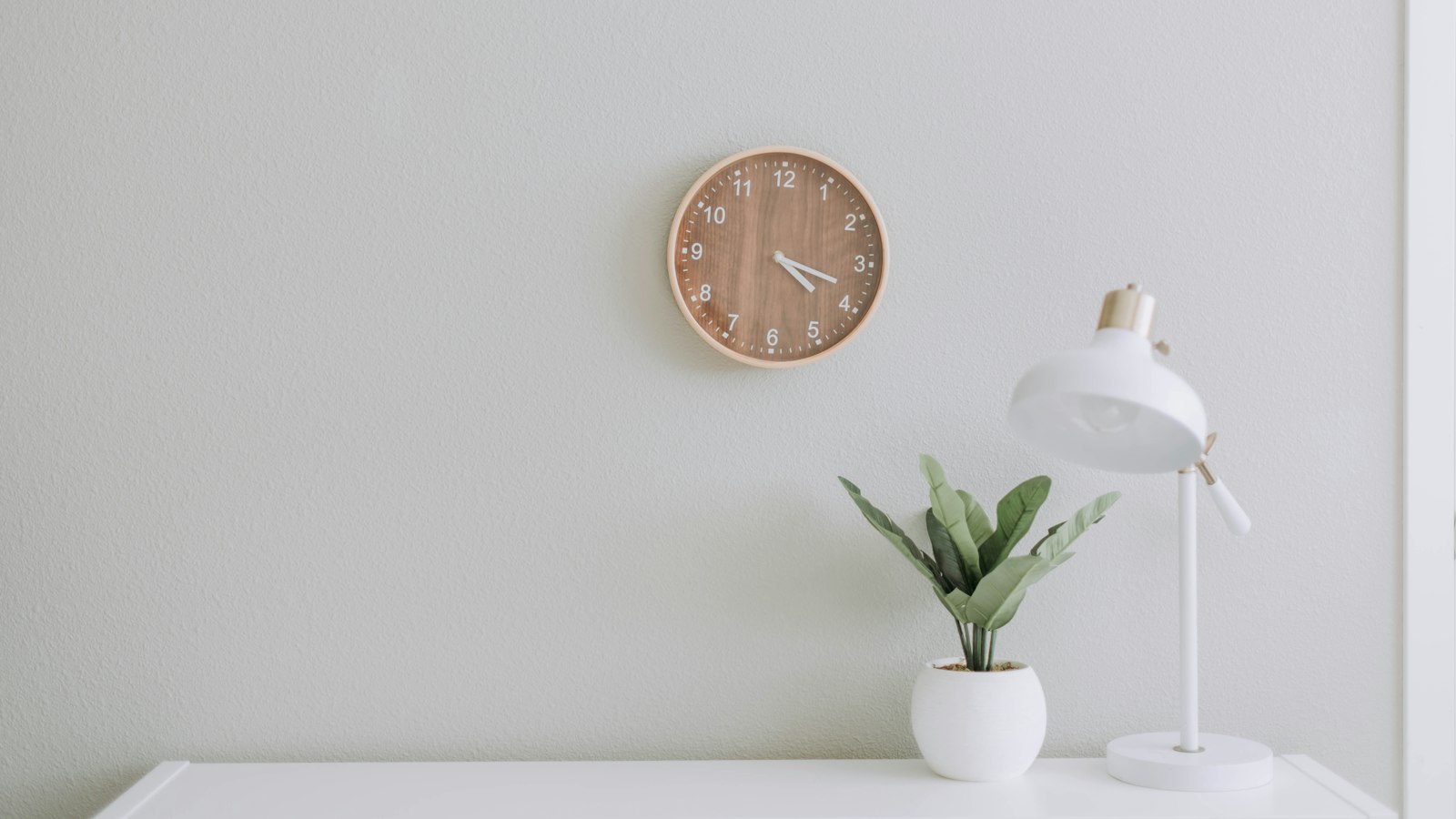 white desk lamp beside green plant