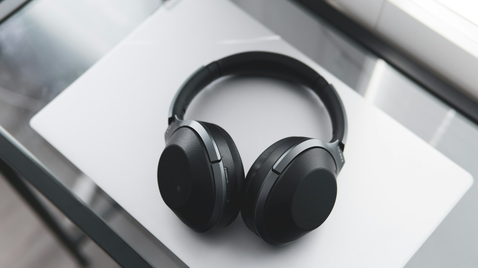 gray and black wireless headphones on desk