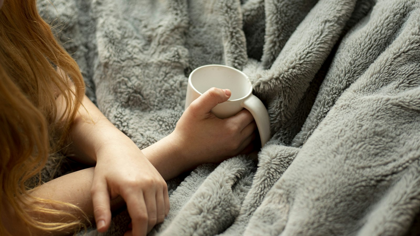 woman holding white ceramic mug