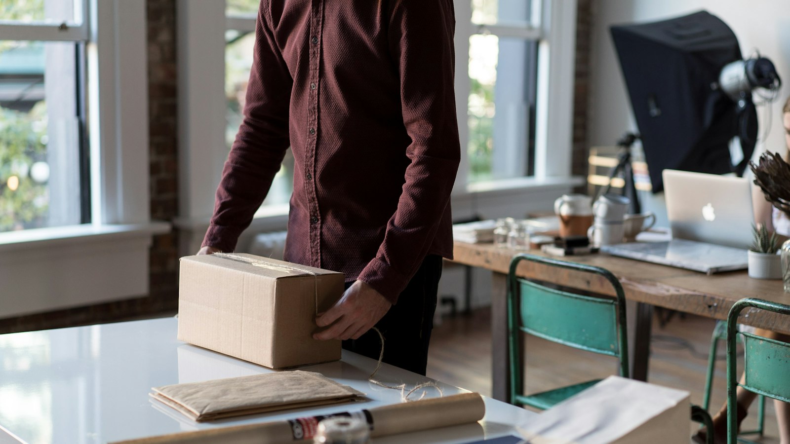 person holding cardboard box on table
