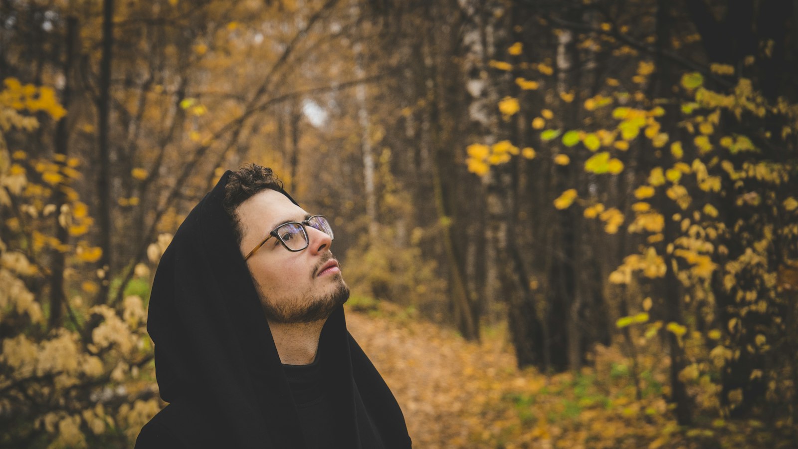 man in black hoodie wearing black framed eyeglasses