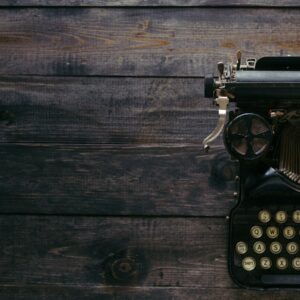 black Corona typewriter on brown wood planks