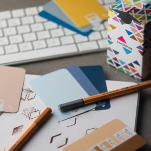a desk with a keyboard, pencils, and various color samples
