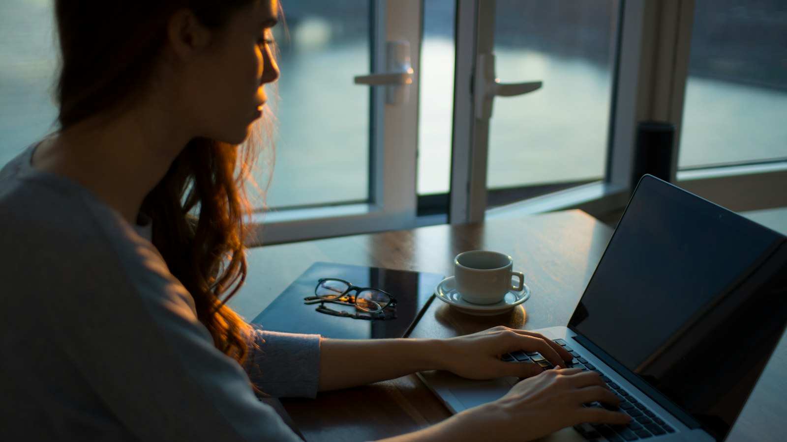 woman sitting beside table using laptop