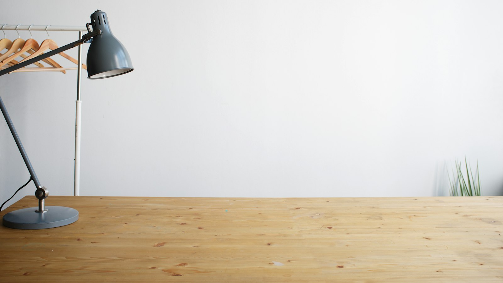 gray balanced-arm lamp on brown wooden table