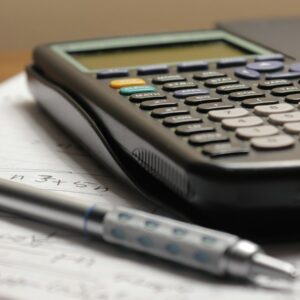 a calculator and a pen sitting on top of a piece of paper