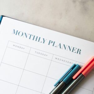a planner with two pens sitting on top of it