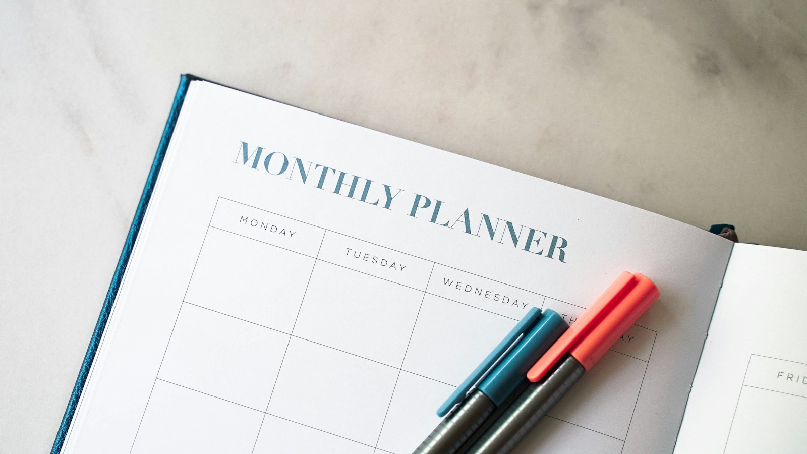 a planner with two pens sitting on top of it