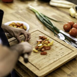 a person cutting up vegetables on a cutting board