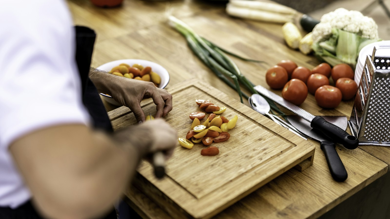 a person cutting up vegetables on a cutting board
