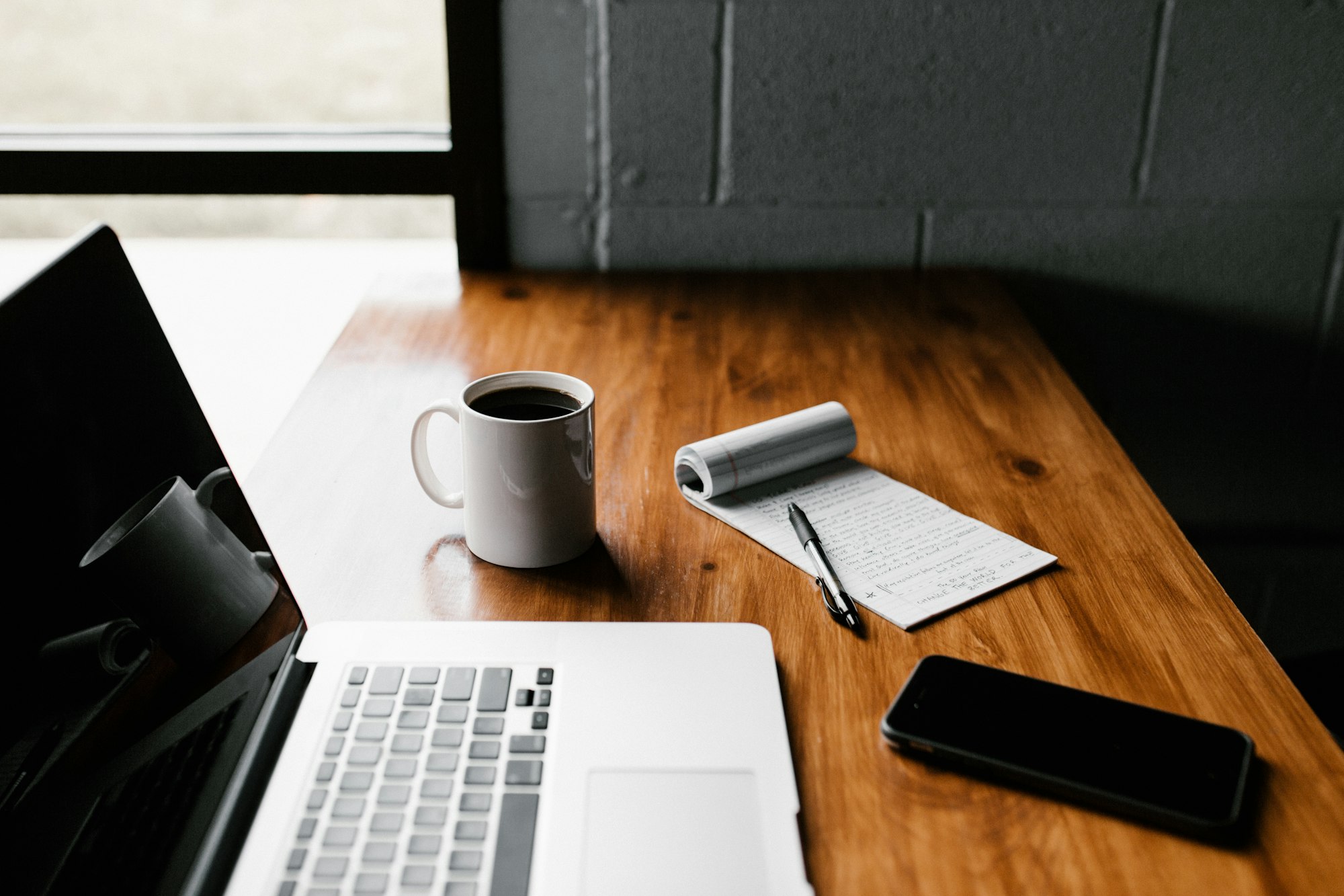 An open notebook and laptop on a calm, tidy desk