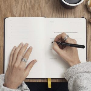 person writing on a book