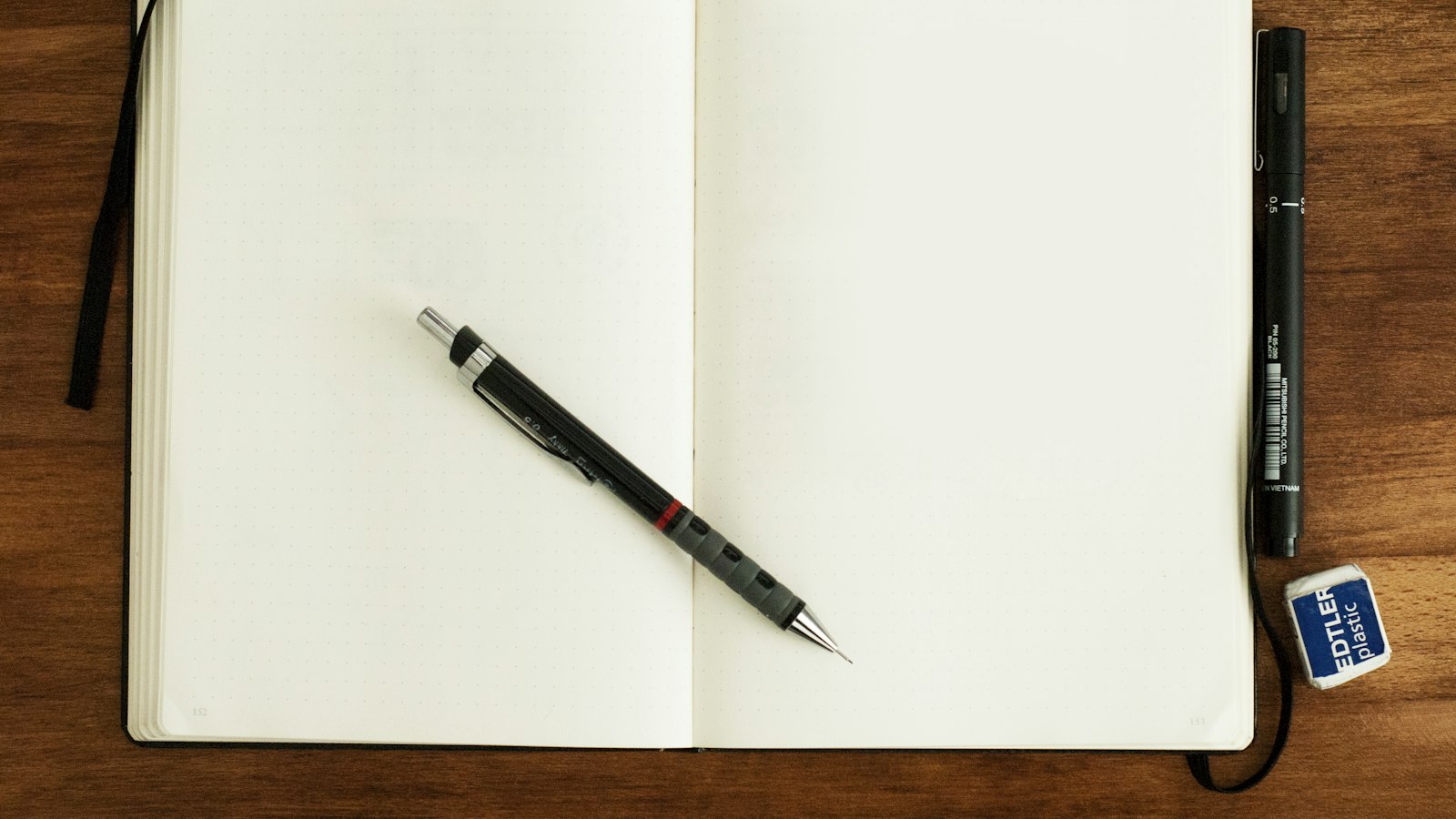 black and silver retractable pen on blank book