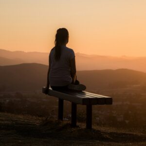 woman sitting on bench over viewing mountain