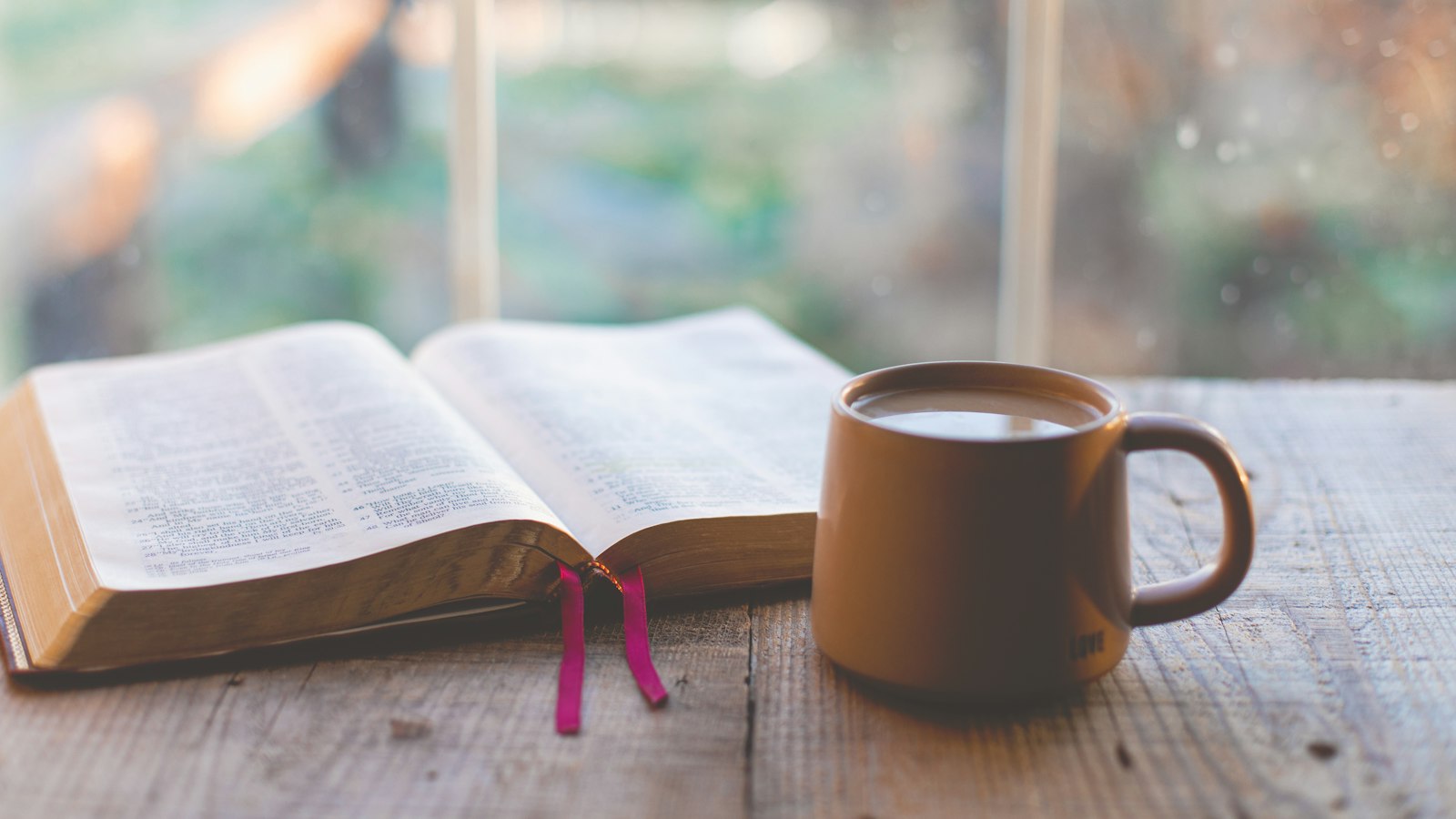 a book and a cup of coffee on a table