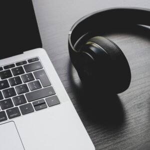 black wireless headphones beside MacBook Pro