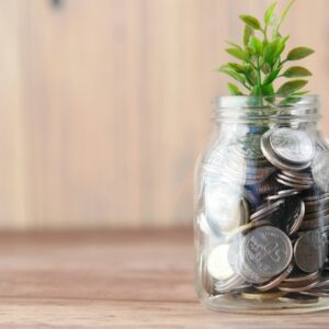 a glass jar filled with coins and a plant