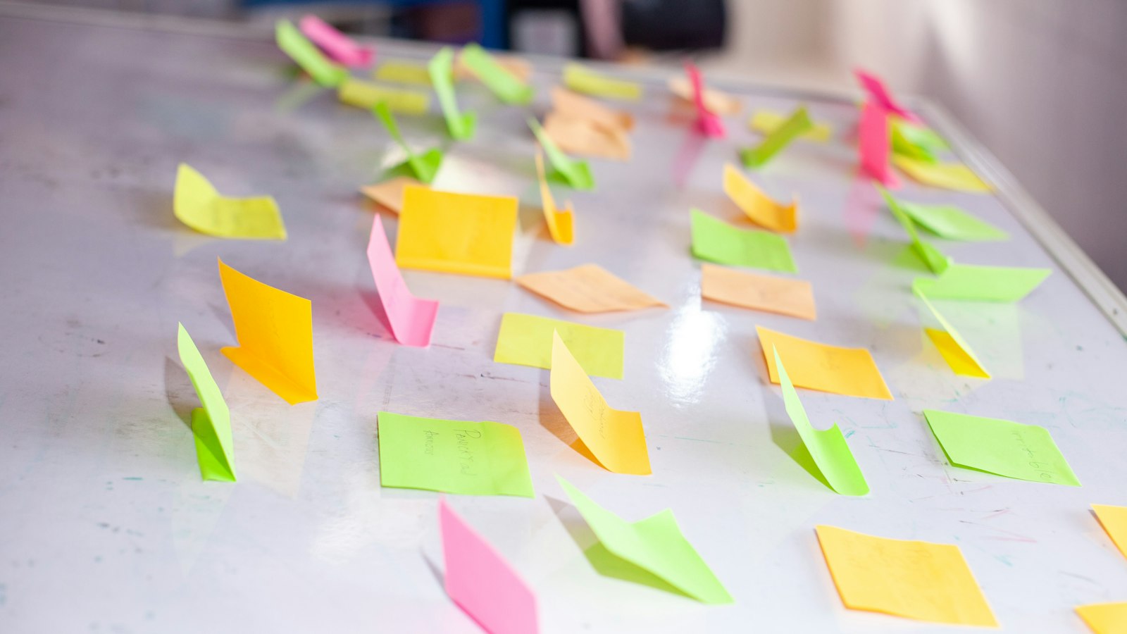 Colorful sticky notes scattered on a white board
