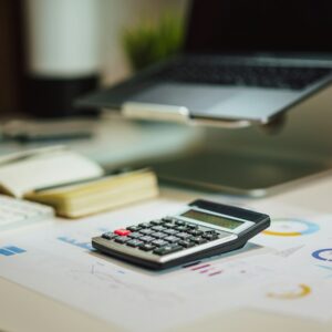 a calculator sitting on top of a table next to a laptop