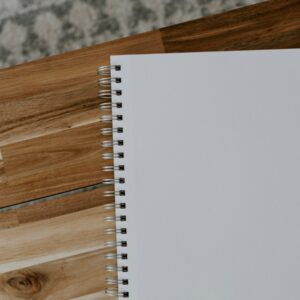 white spiral notebook on brown wooden table