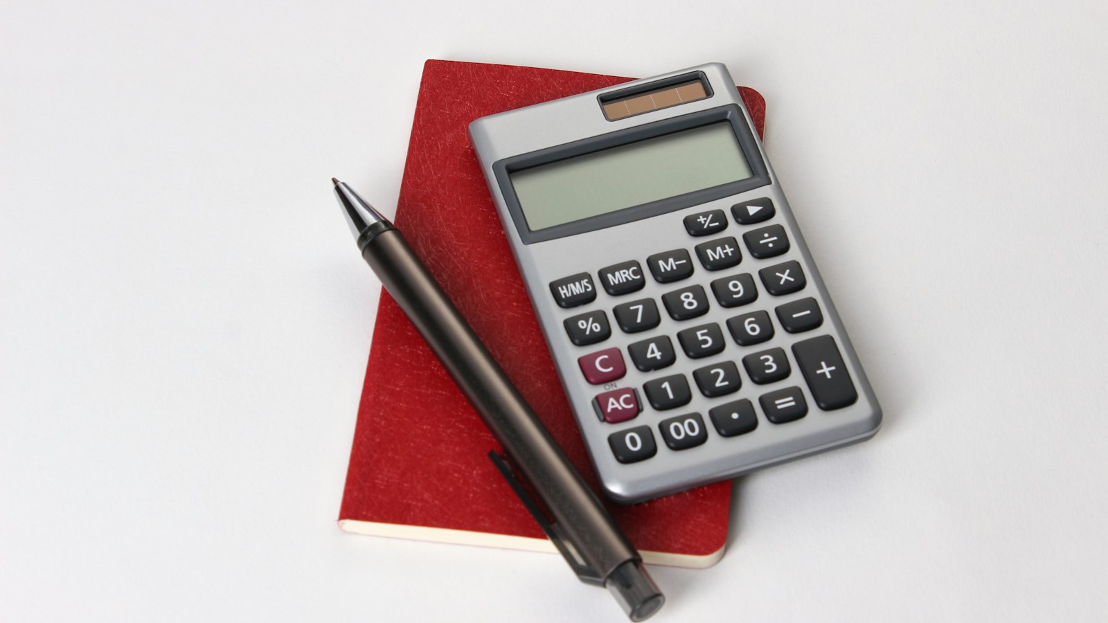 black and silver calculator beside black pen