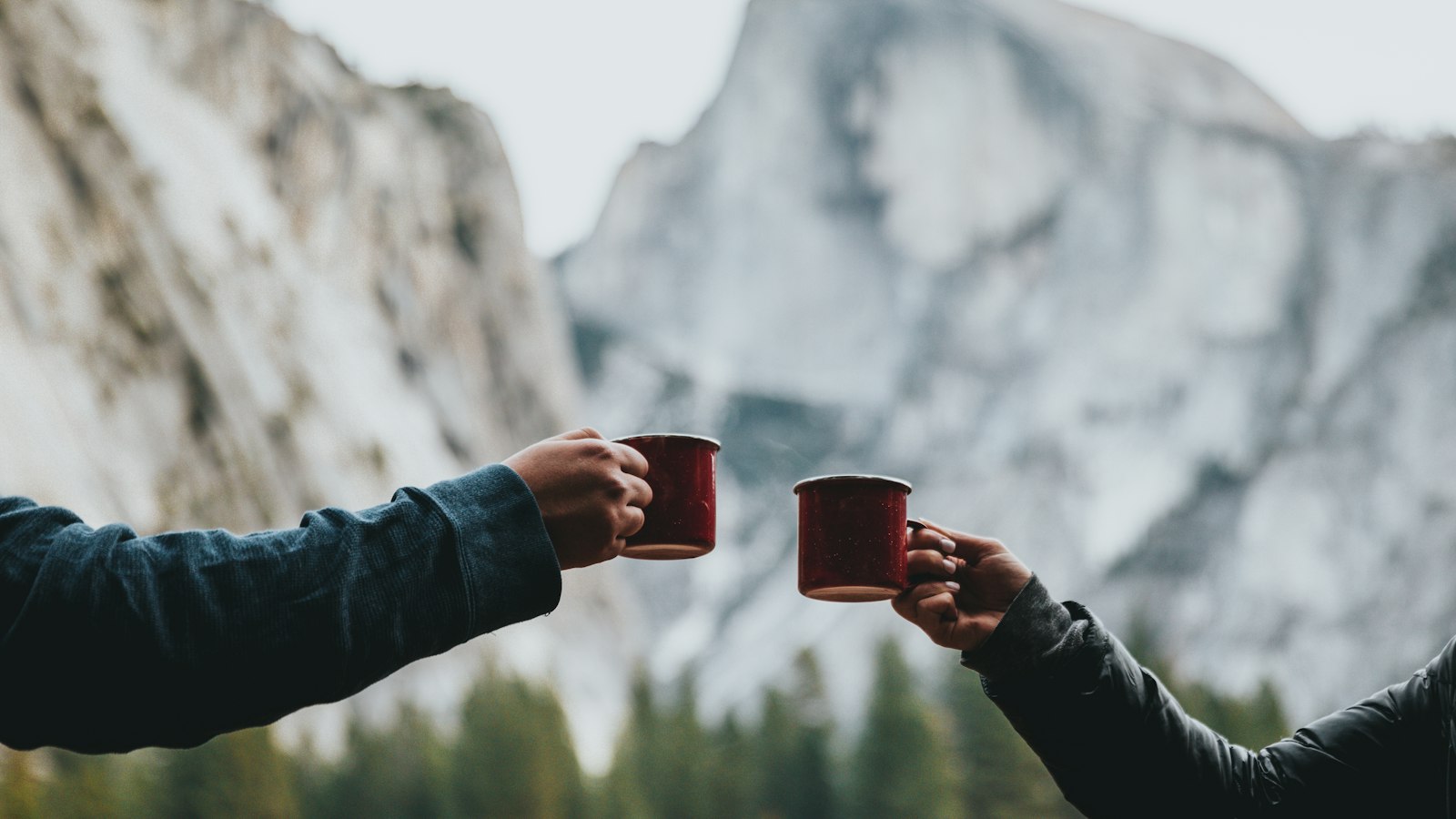 two person holding red mugs