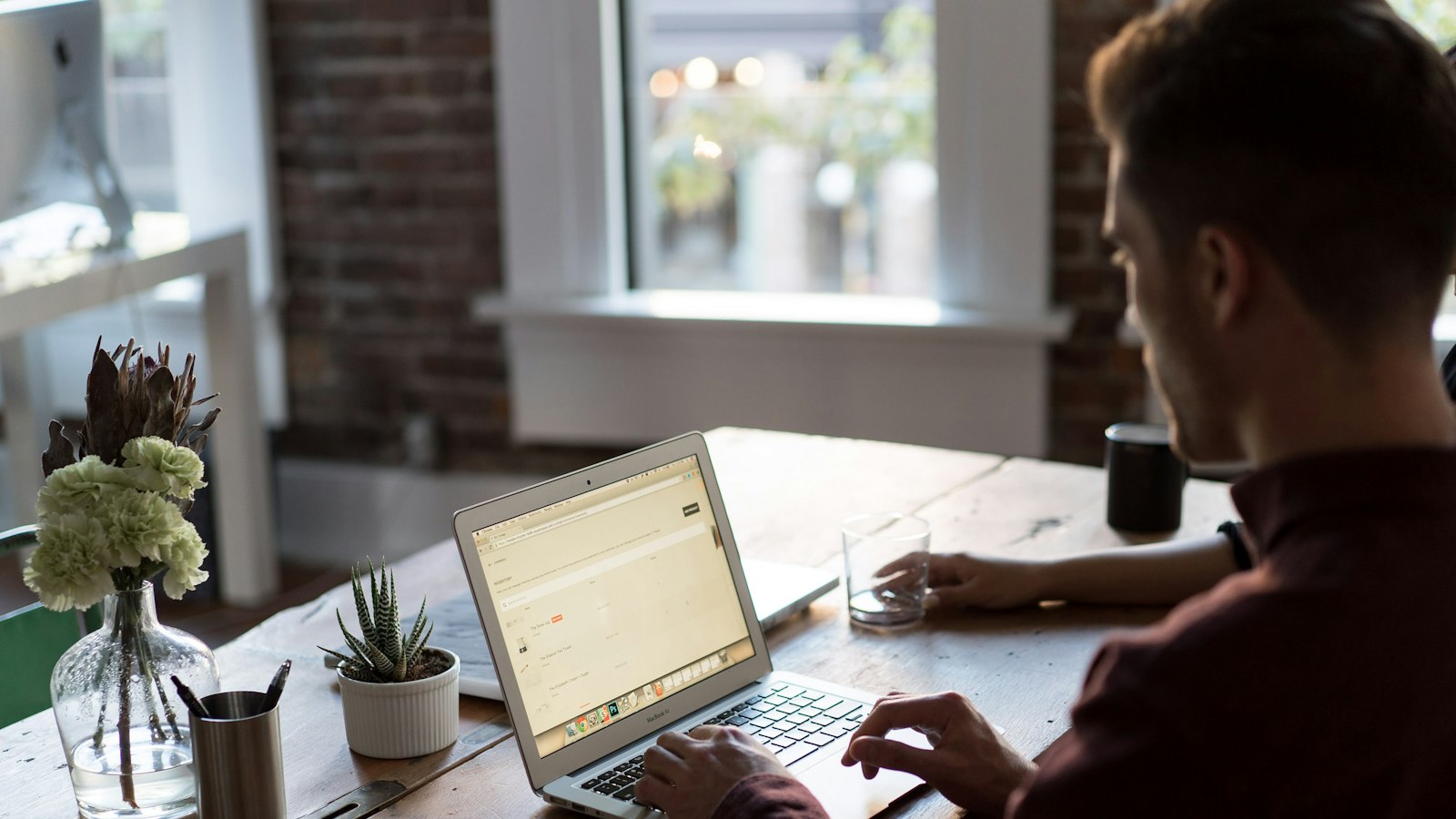 man operating laptop on top of table
