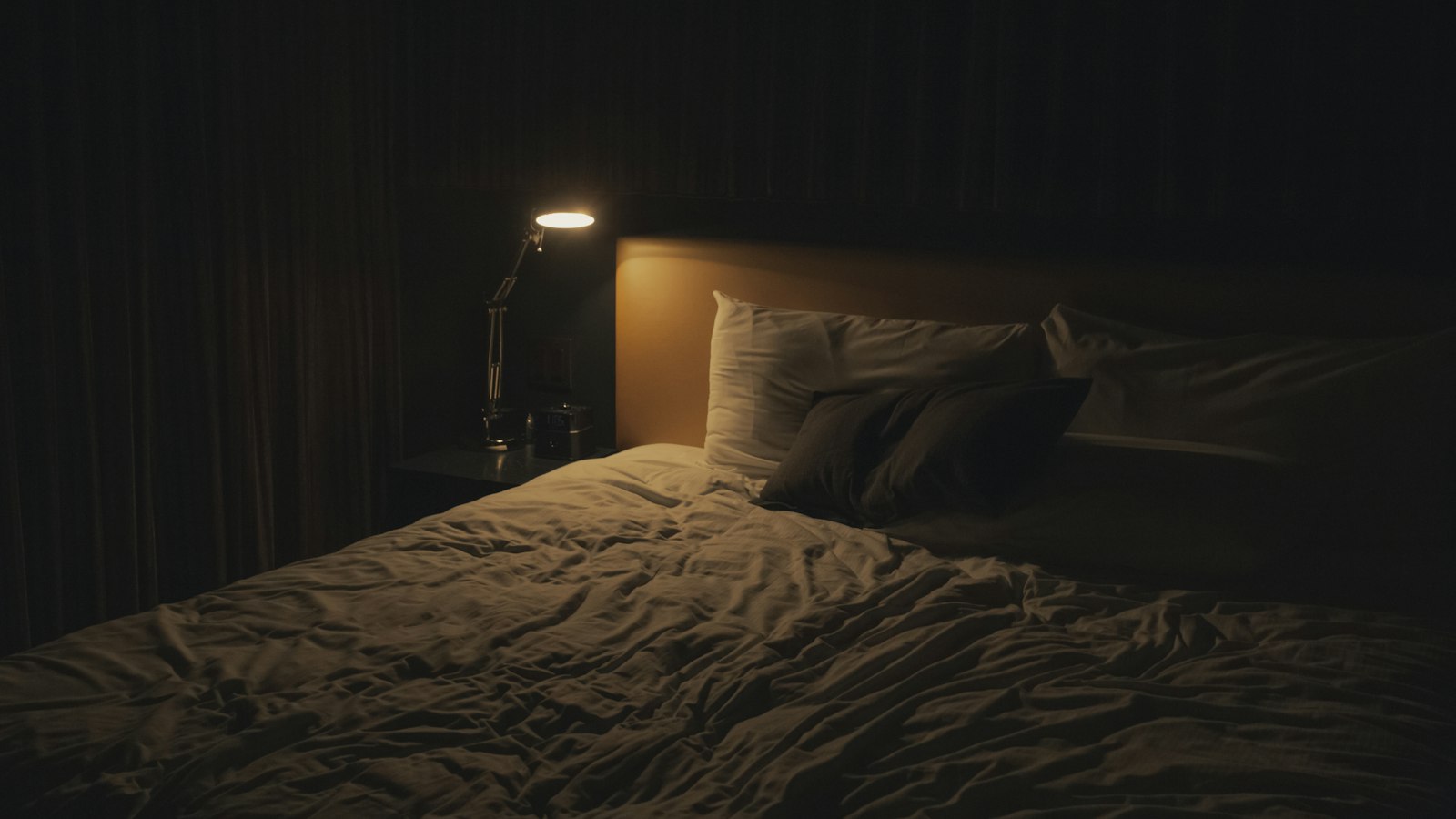 table lamp turned-on near bed
