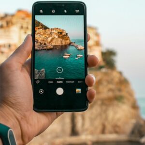 person holding a phone near cliff during daytime