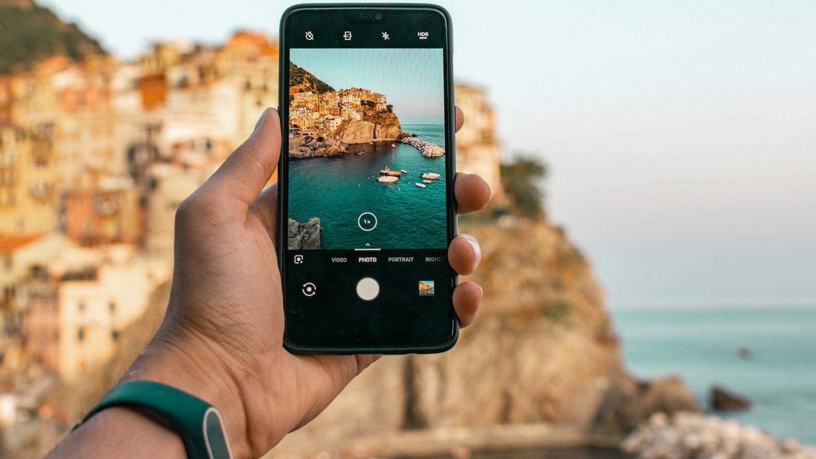 person holding a phone near cliff during daytime
