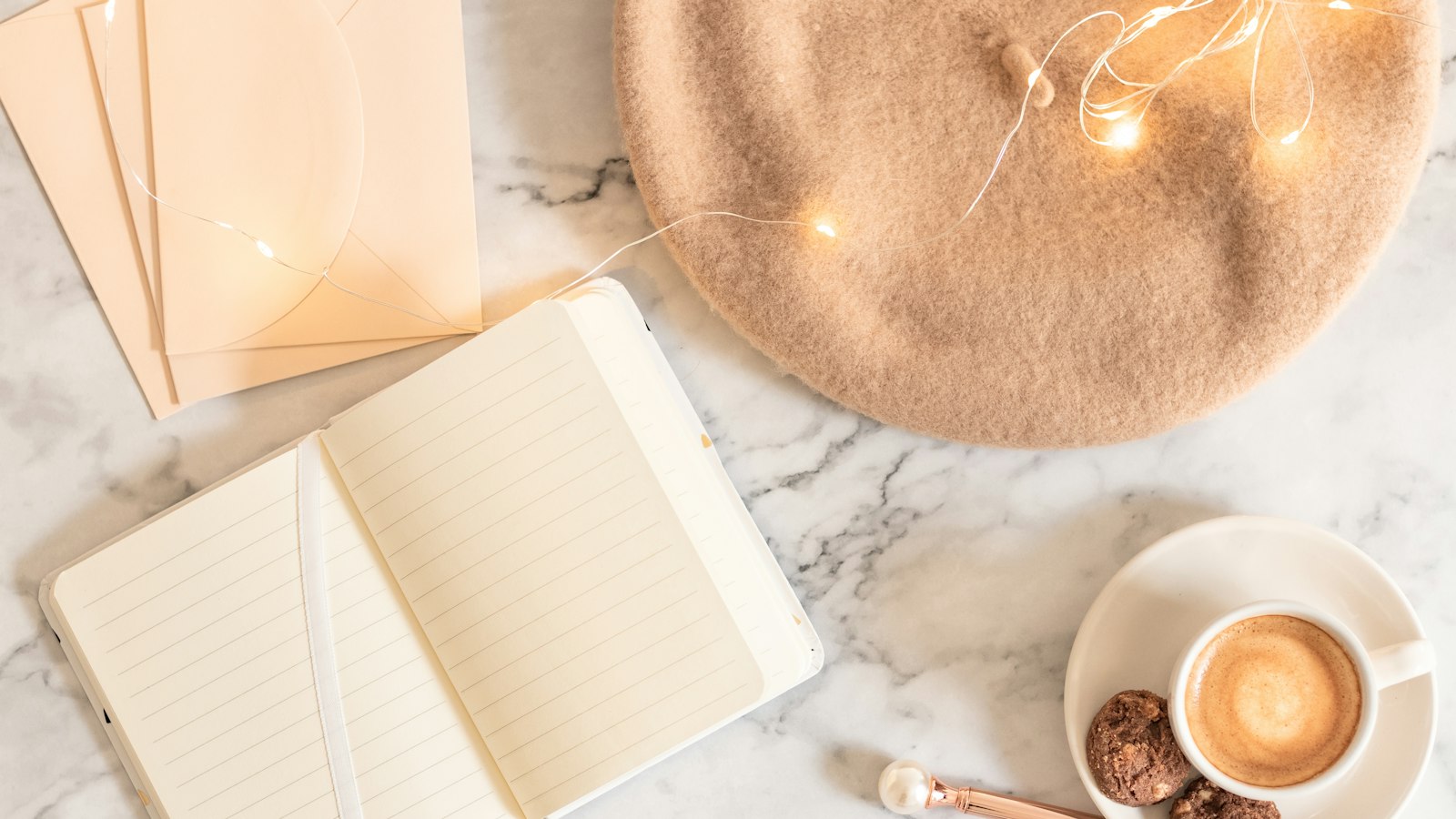 a cup of coffee and a notebook on a marble table