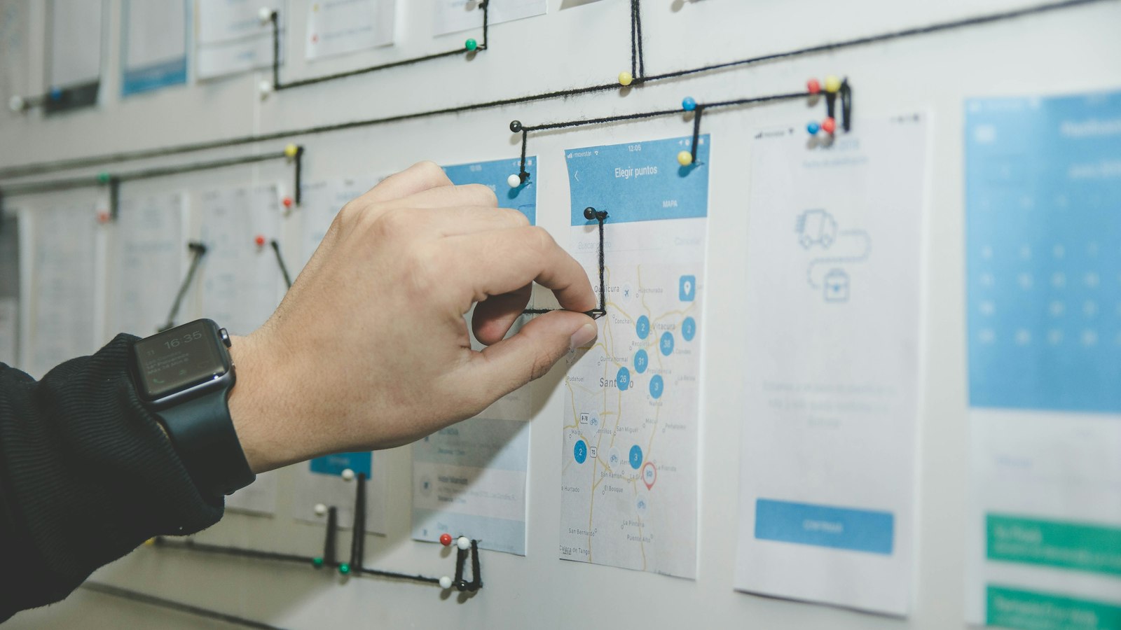 person working on blue and white paper on board