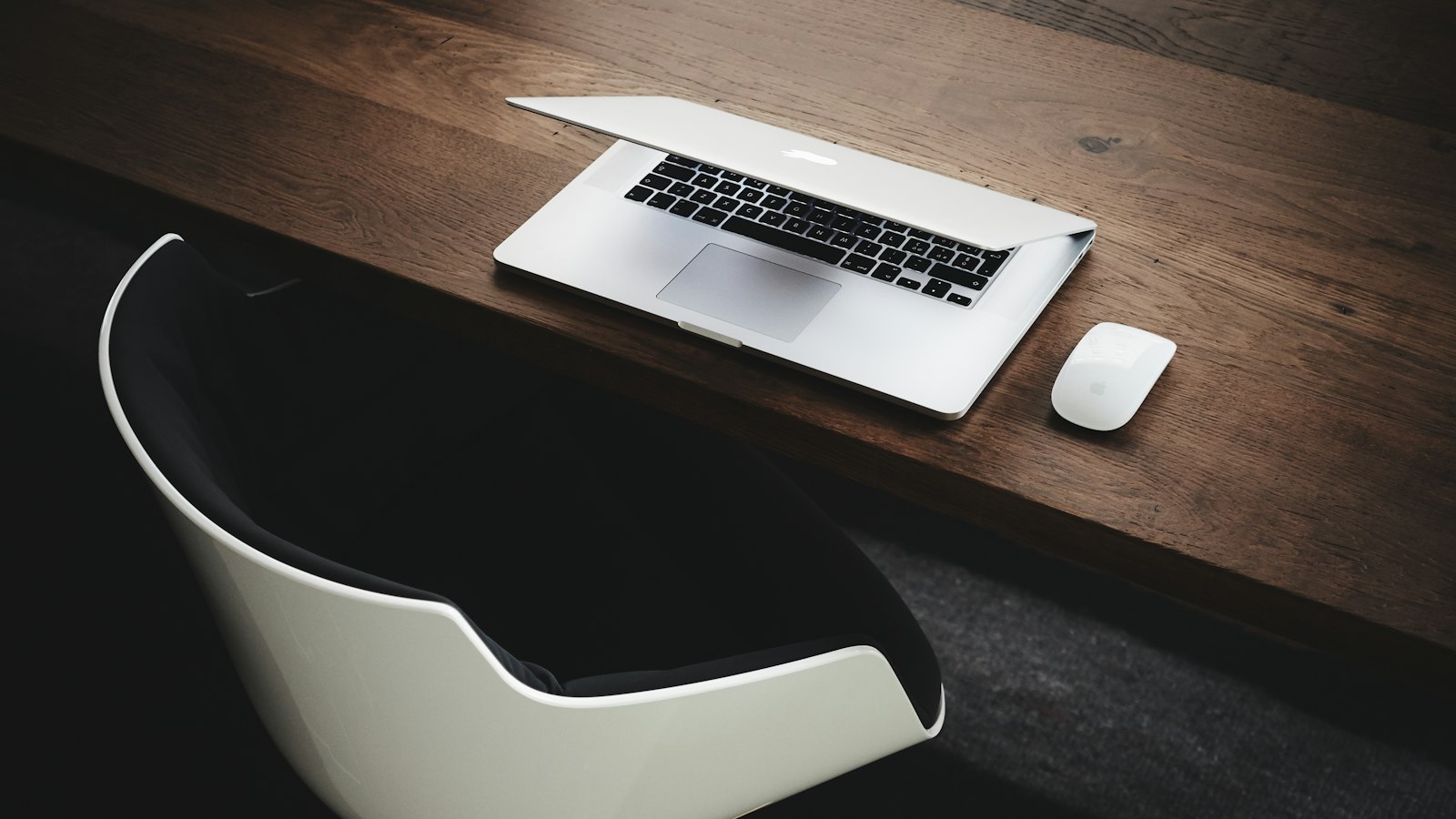 Apple MacBook beside computer mouse on table